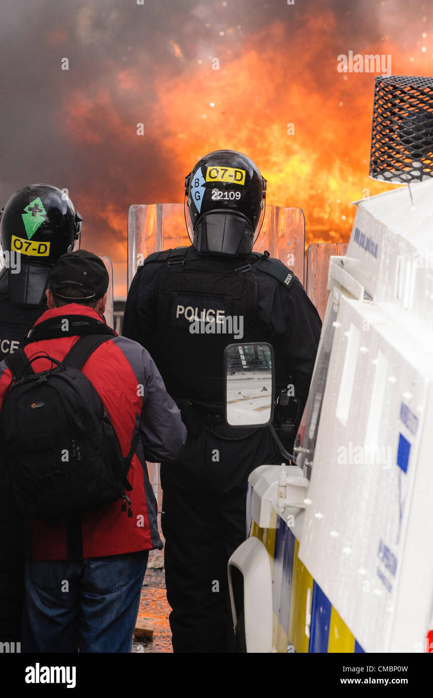 Belfast, 12/07/2012 - un'auto è impostato sul fuoco e spinto verso le linee di polizia come la violenza scoppia in Ardoyne 12 luglio successivo ordine arancione parade Foto Stock