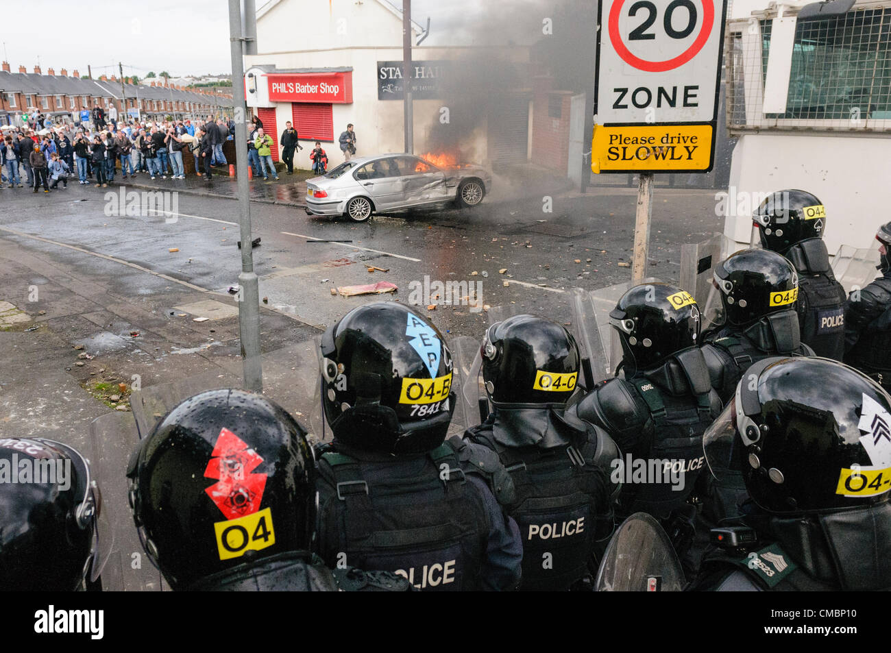 Belfast, 12/07/2012 - un'auto è impostato sul fuoco e spinto verso le linee di polizia come la violenza scoppia in Ardoyne 12 luglio successivo ordine arancione parade Foto Stock