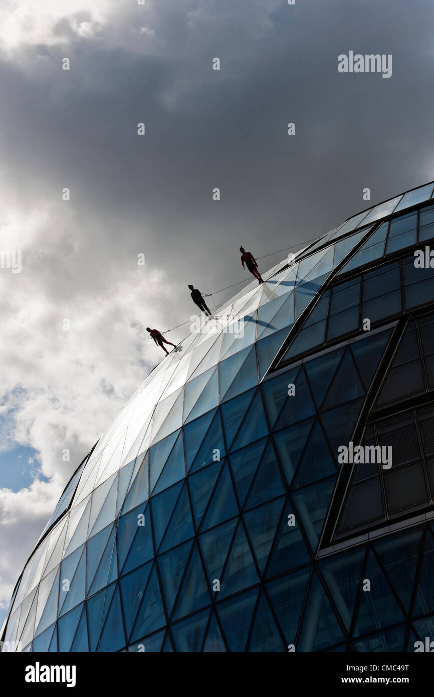 Domenica 15 Luglio, Municipio di Londra. Il leggendario New York coreografo, Elizabeth Streb e la sua compagnia di ballo eseguire un giro sulle alture della City Hall di Londra di questa mattina in vista degli anelli olimpici appesi da Tower Bridge. I giochi olimpici inizia a Londra il 27 luglio e questo evento fa parte delle olimpiadi culturali. Foto Stock