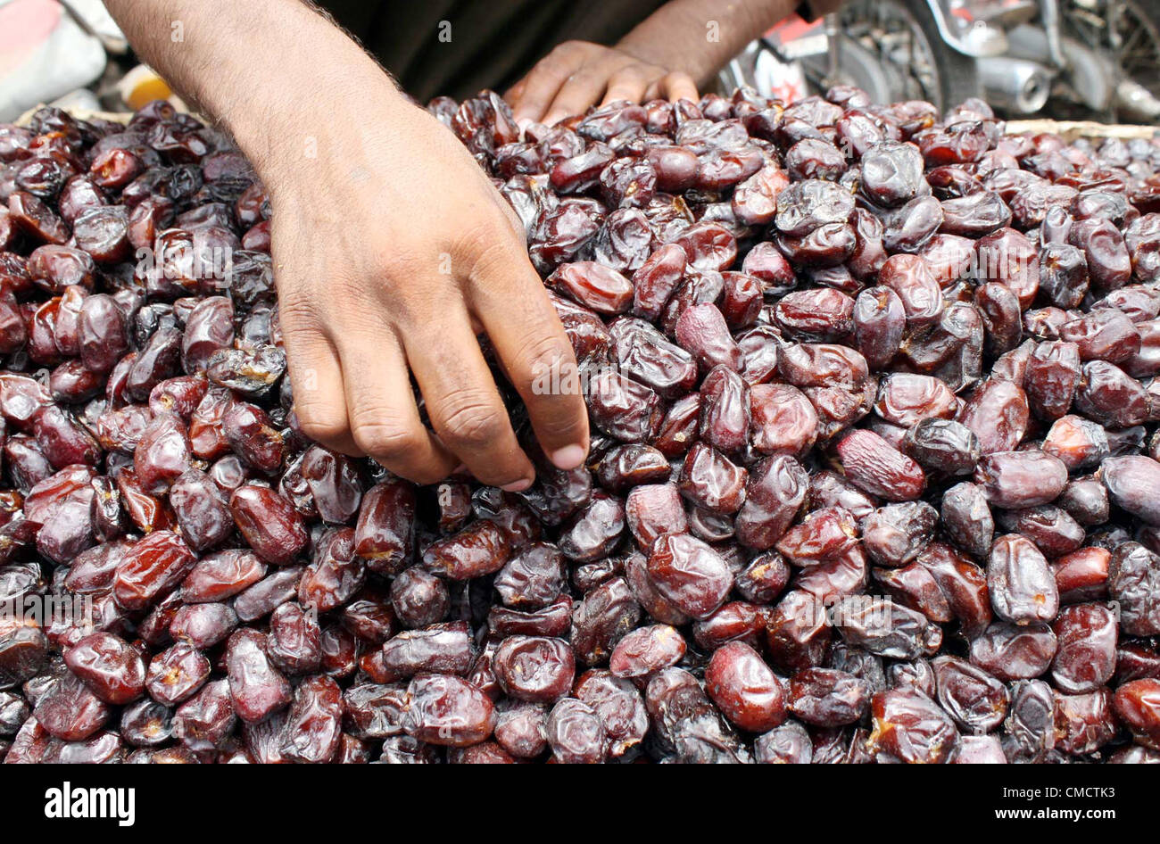 Il fornitore provvede date per attirare i clienti su un push-carrello come domanda di date è aumentato in città, precedendo il mese sacro del Ramadan-ul-Mubarak a Karachi il Venerdì, 20 Luglio 2012 Foto Stock