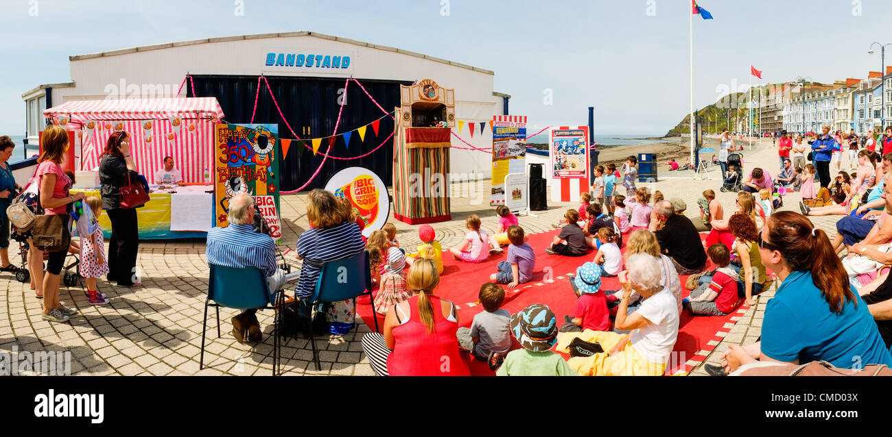 Aberystwyth Wales UK Luglio 21 2012. Un punzone e Judy show intrattiene la folla di turisti sul lungomare al primo caldo giorno d'estate dopo molte settimane di umido e freddo. L evento è stato parte del lungo un anno a livello nazionale "Brig Grin Festival', (finanziato dal Patrimonio del fondo della lotteria) contrassegno Mr Punch 350esimo compleanno, ed era il solo un episodio in Galles Foto ©keith morris Foto Stock