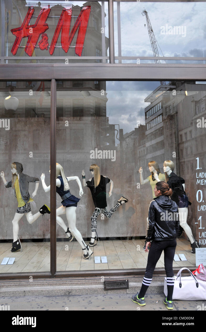 Regent Street, Londra, Regno Unito. Il 21 luglio 2012. H&M store window su Regent Street come i suoi negozi sono decorate con le Olimpiadi e le correlate allo sport bandiere, inserzioni e decorazioni per finestre, in un'offerta di denaro contante in su le Olimpiadi di Londra 2012. Foto Stock