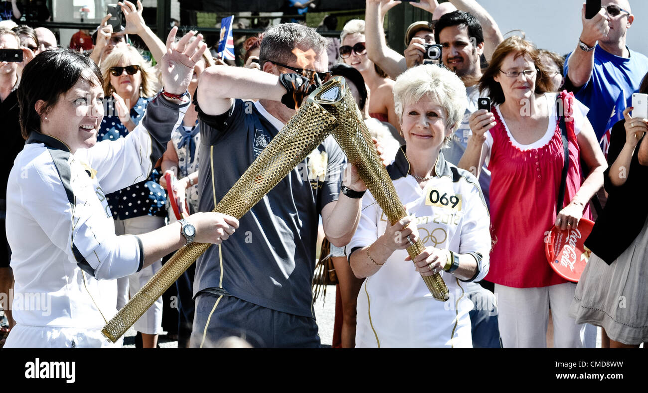 23/07/12 Londra, UK: Ex cricketer Amy Terriere passa la fiamma olimpica per Julie Galloway su Church Road, Croydon. Foto Stock