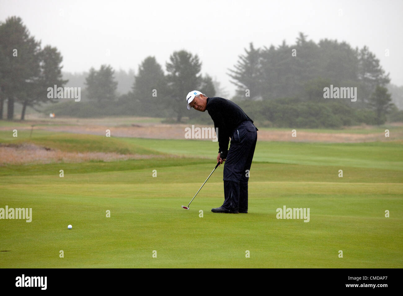 23 luglio 2012, Kilmarnock (Barassie) Golf Club, Troon, Ayrshire, in Scozia, Regno Unito, Isao Aoki, dal Giappone, professional golfer,completando il suo turno di qualificazione per il 2012 Royal e antiche anziani una concorrenza aperta. Egli sta mettendo il diciottesimo verde. Egli affonda questo birdie putt per un punteggio finale di 74. Foto Stock