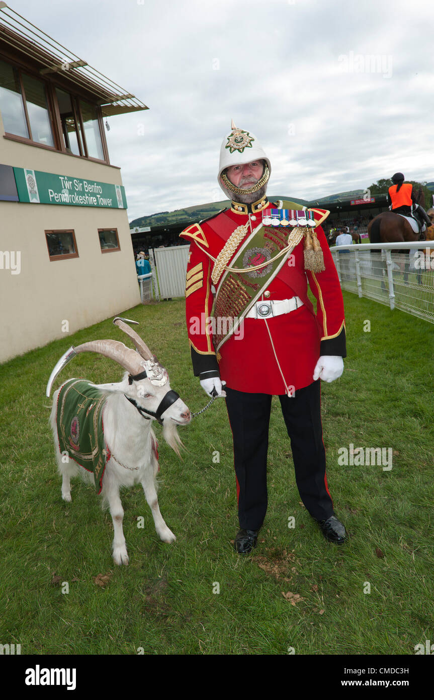 Il 23 luglio 2012. Llanelwedd, Builth Wells, Regno Unito. Capra Sergente Maggiore David Joseph stand con Royal Windsor capra bianca Shenkin III prima della sfilata nell'anello principale al 2012 Royal Welsh Agricultural Show. Photo credit: Graham M. Lawrence/Alamy Live News. Foto Stock