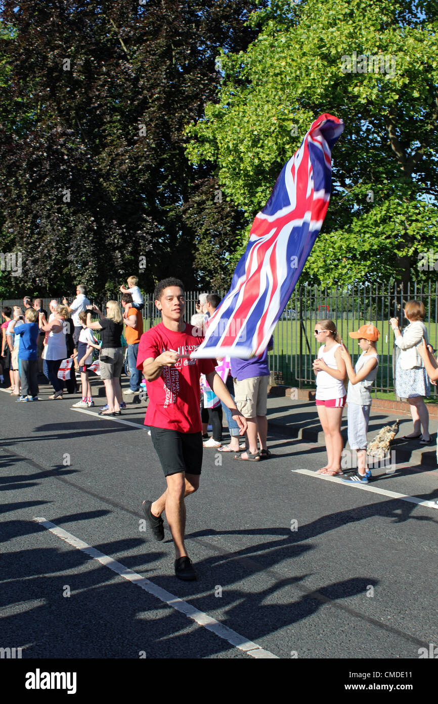 Il 24 luglio 2012. Gancio Road, Chessington, SURREY REGNO UNITO. 8.30. Torcia Olimpica giorno 67. Un portabandiera che è parte della Coca Cola street entertainment. Coca Cola sono uno dei partner di presentazione di Londra 2012. Credito: Julia Gavin / Alamy Live News Foto Stock