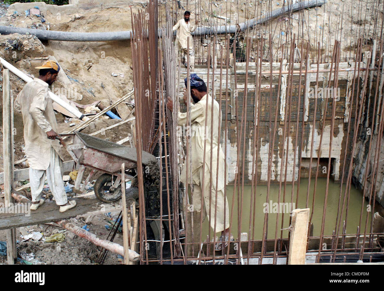 Fatiche occupato nei lavori di costruzione della rete fognaria di scarico acqua a Kharadar area in Karachi martedì 24 luglio, 2012. Foto Stock