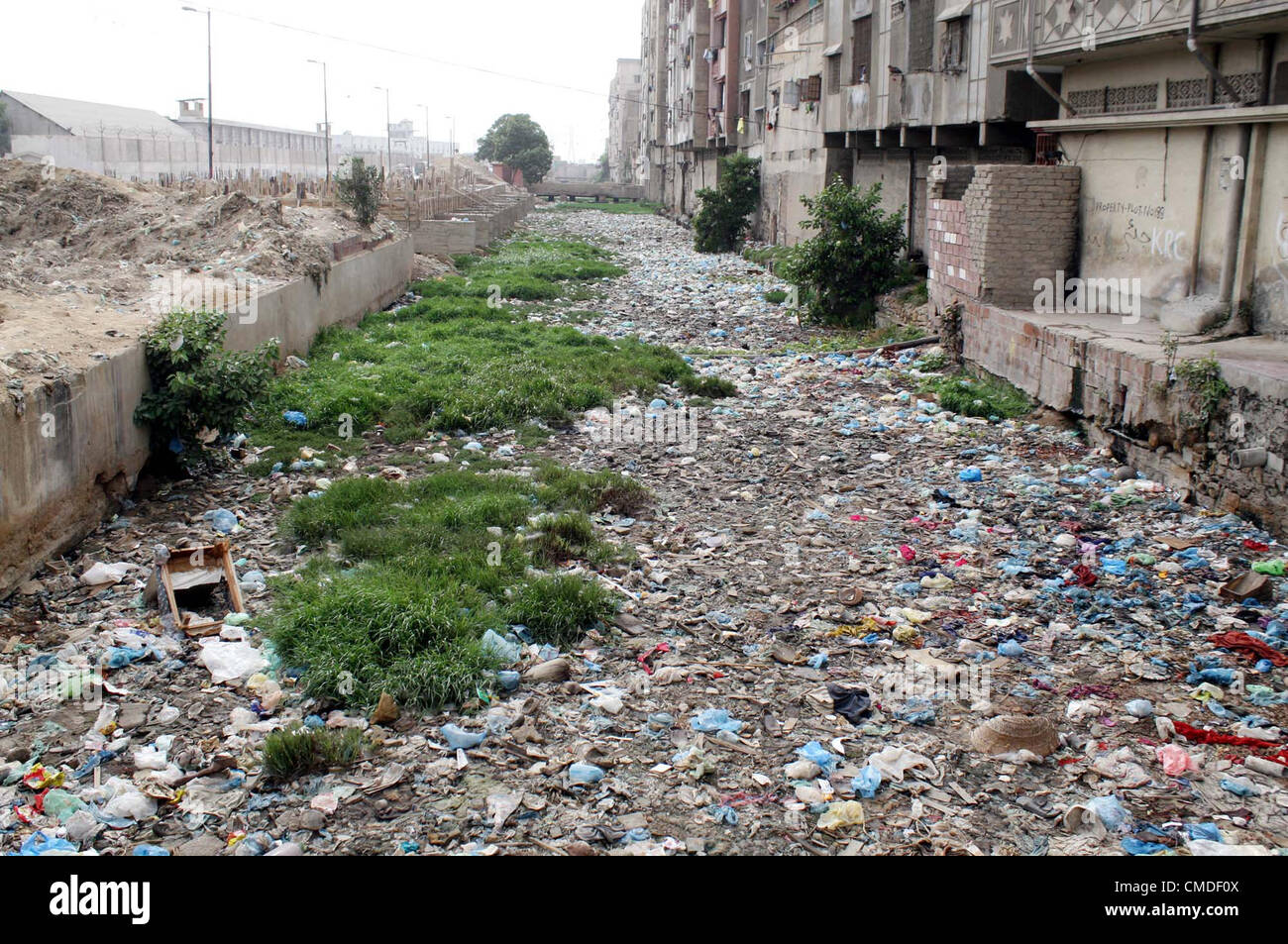 Una vista di aprire la rete fognaria di scarico di acqua che riempie con sacchi di polietilene, bussole e garbage ha bisogno dell attenzione del dipartimento interessato a Kharadar area in Karachi martedì 24 luglio, 2012. Foto Stock