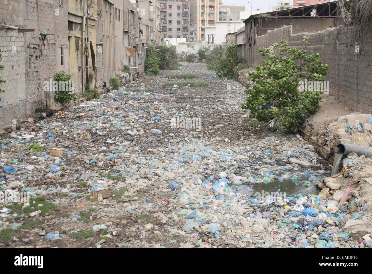 Una vista di aprire la rete fognaria di scarico di acqua che riempie con sacchi di polietilene, bussole e garbage ha bisogno dell attenzione del dipartimento interessato a Kharadar area in Karachi martedì 24 luglio, 2012. Foto Stock