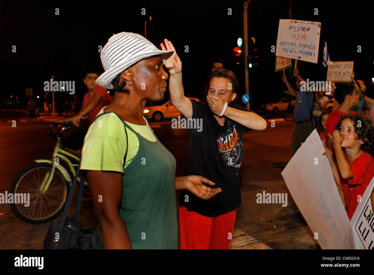 Una donna israeliana tiene il respiro davanti a un migrante africano per implicare che la presenza di migranti africani è un pericolo per la salute durante una protesta contro i lavoratori migranti africani e i richiedenti asilo che vivono nella periferia meridionale di Tel Aviv Israele Foto Stock