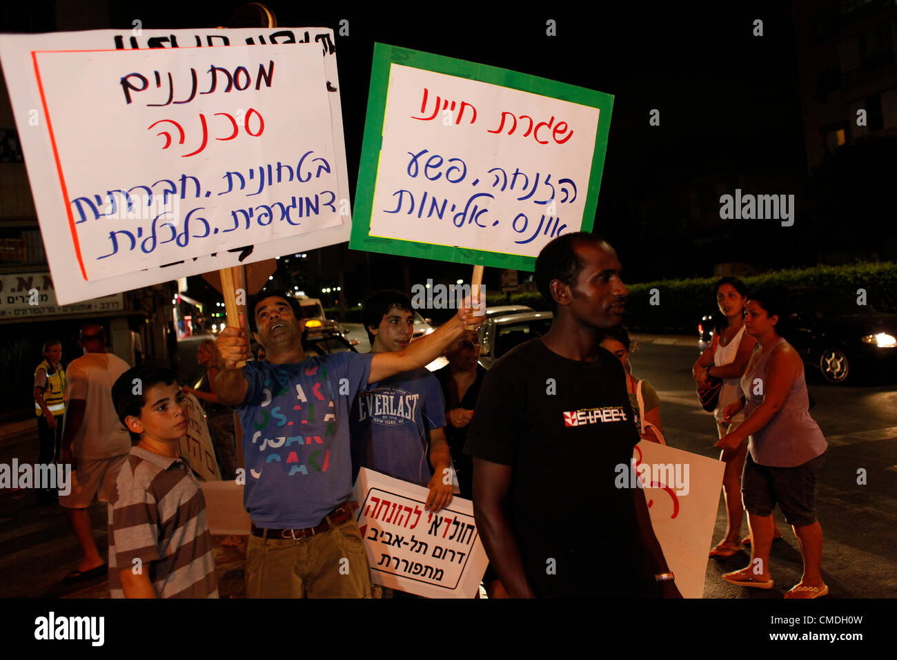 Le persone in possesso di un cartello che recita ' infiltrati sono demografici sicurezza sociale economica pericolo' nella parte anteriore di un Africano pedone, durante una dimostrazione contro africana di lavoratori migranti e richiedenti asilo che vivono nella periferia sud di Tel Aviv Foto Stock