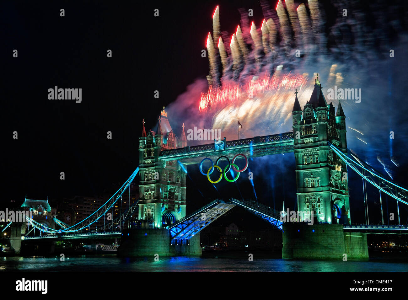 London, England, Regno Unito venerdì 27 luglio 2012 il Tower Bridge fuochi d'artificio illuminano il fiume Tamigi come la torcia olimpica prende la tappa finale del viaggio verso lo Stadio Olimpico. Londra, ospite del trentesimo Giochi Olimpici preparato per la cerimonia di apertura con un fuoco d'artificio e display luminoso a Tower Bridge, City of London, England, Regno Unito Foto Stock