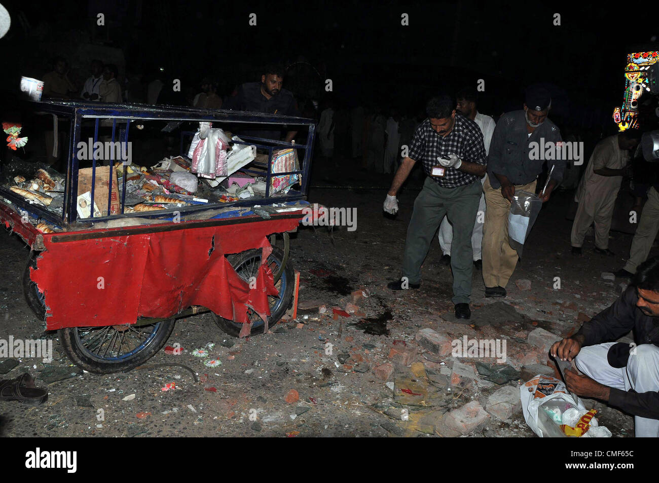 2 agosto 2012. Il pakistan dei funzionari di polizia di esaminare il sito di twin di blasti in un mercato della frutta a Lahore Agosto 02, 2012. Almeno 23 persone sono state ferite quando due esplosioni ha scosso la città durante le ore notturne. Foto Stock