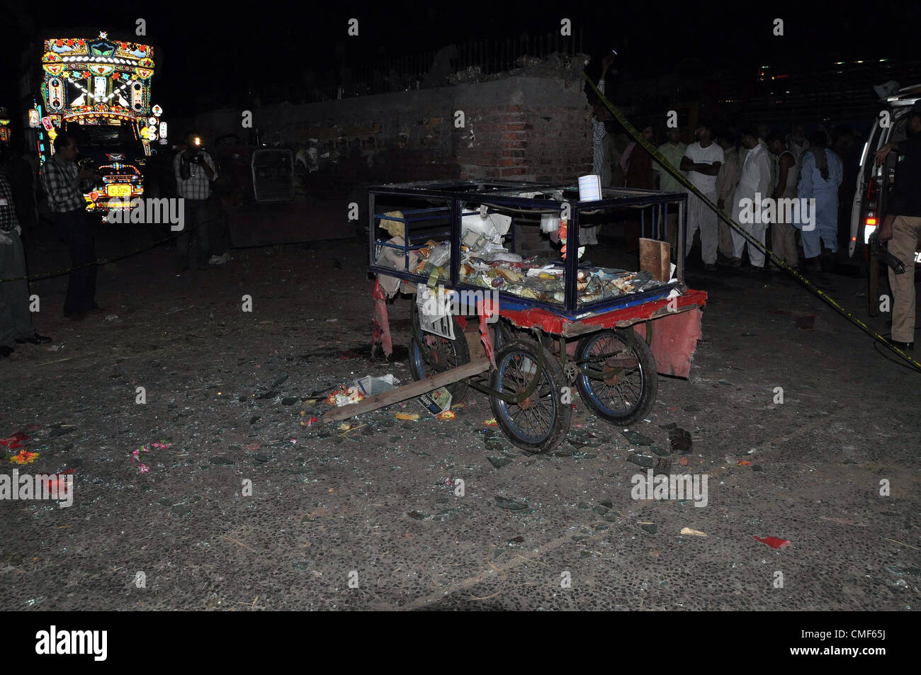 2 agosto 2012. Il pakistan dei funzionari di polizia di esaminare il sito di twin di blasti in un mercato della frutta a Lahore Agosto 02, 2012. Almeno 23 persone sono state ferite quando due esplosioni ha scosso la città durante le ore notturne. Foto Stock