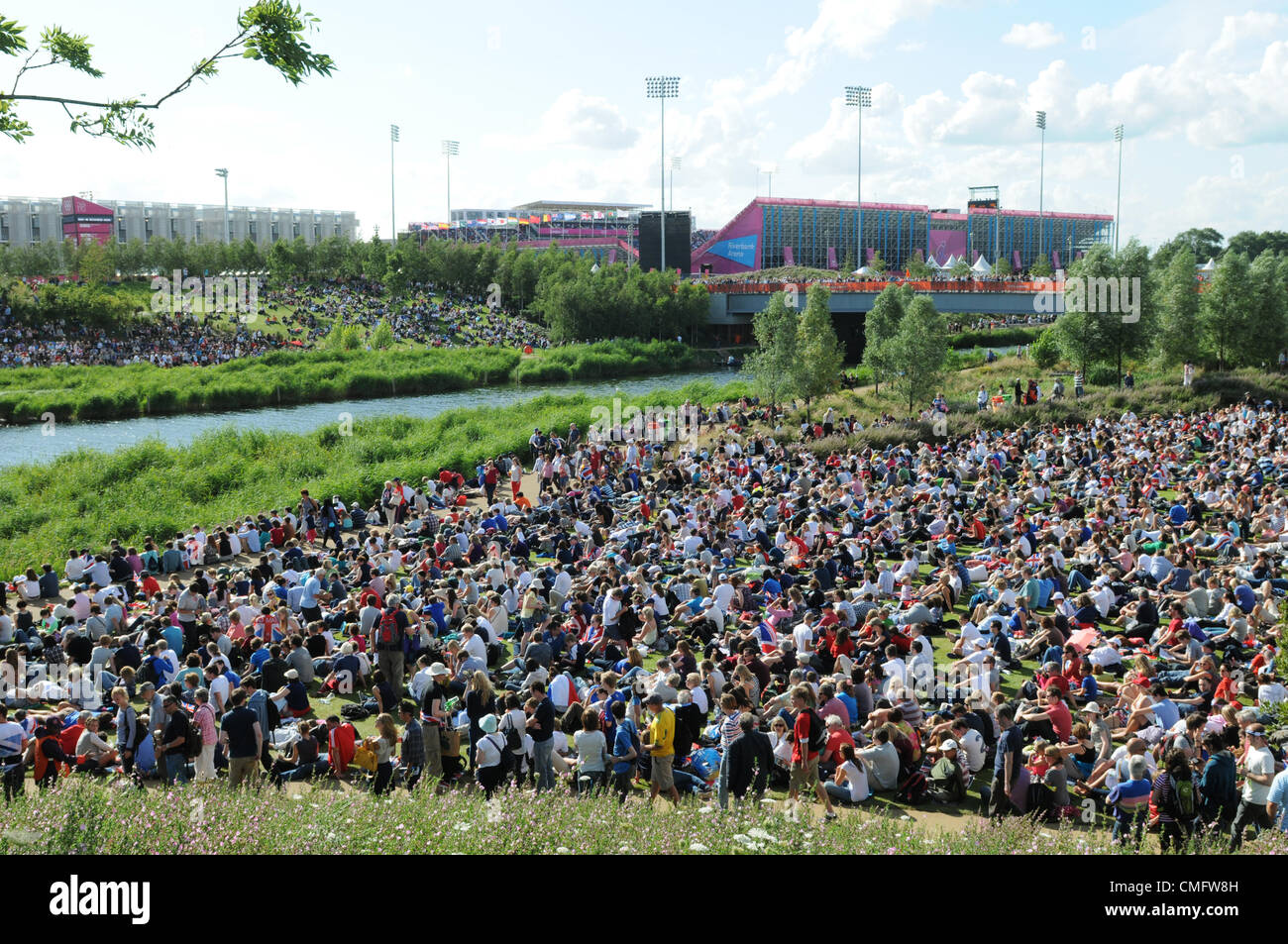 La folla si radunano sotto il sole per guardare la TV in diretta la copertura di Olympic finals sul grande schermo TV al Park vivono dentro il 2012 Olympic Park, a Londra il 3 agosto 2012. Foto Stock