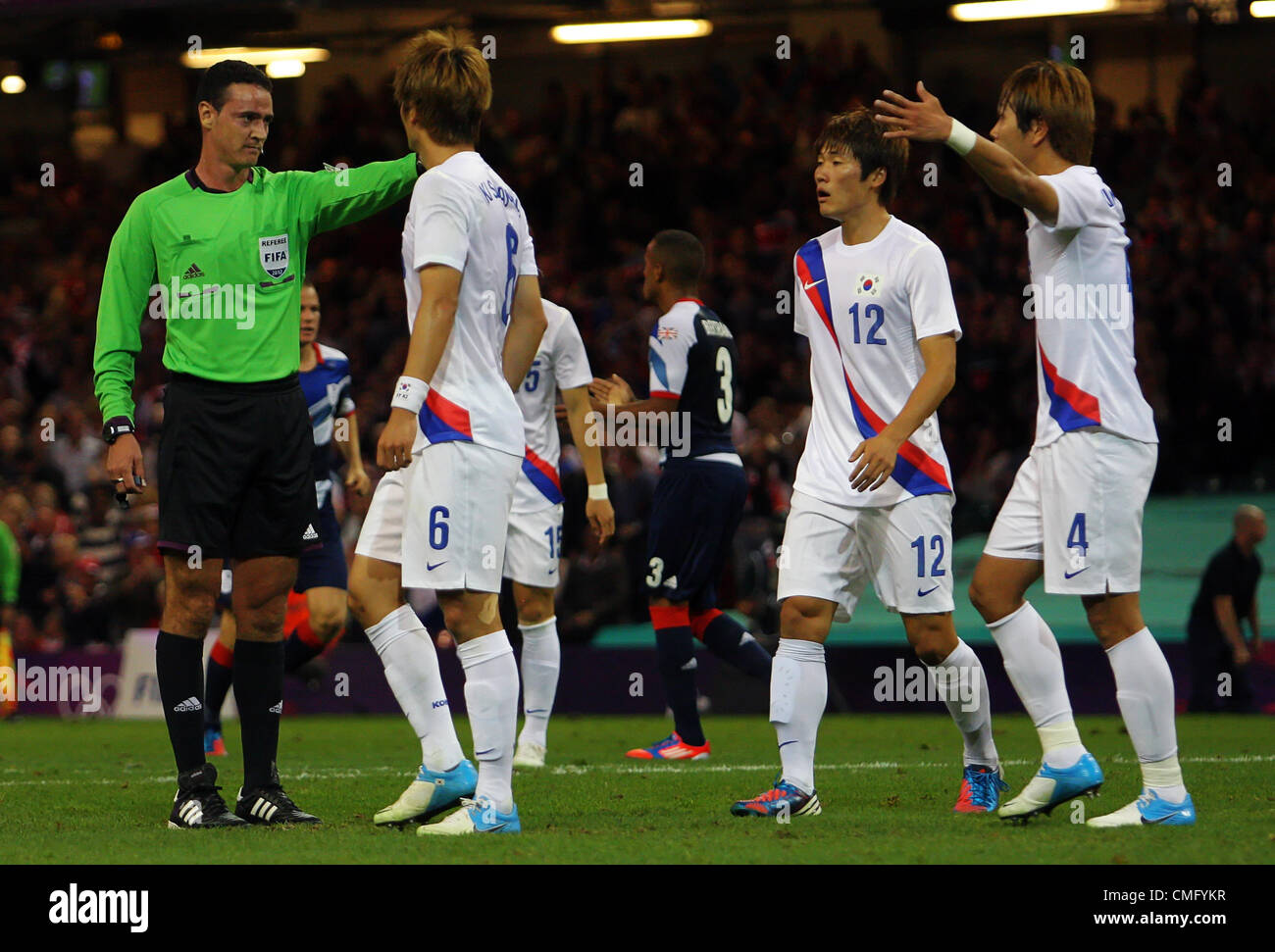 04.08.2012 Cardiff Wales. La Corea del Sud i giocatori circondano l'arbitro dopo aver assegnato un calcio di rigore contro di essi durante il calcio alle Olimpiadi uomini quarto gioco finale tra TeamGB e Corea del Sud. Corea del Sud vincere molto serrato match 5-4 sulle sanzioni dopo la abbinati finita 1-1 dopo un tempo supplementare. Corea del sud ora procedere a Semi Finali dove svolgere il Brasile che ha battuto Honduras 3-2. Foto Stock