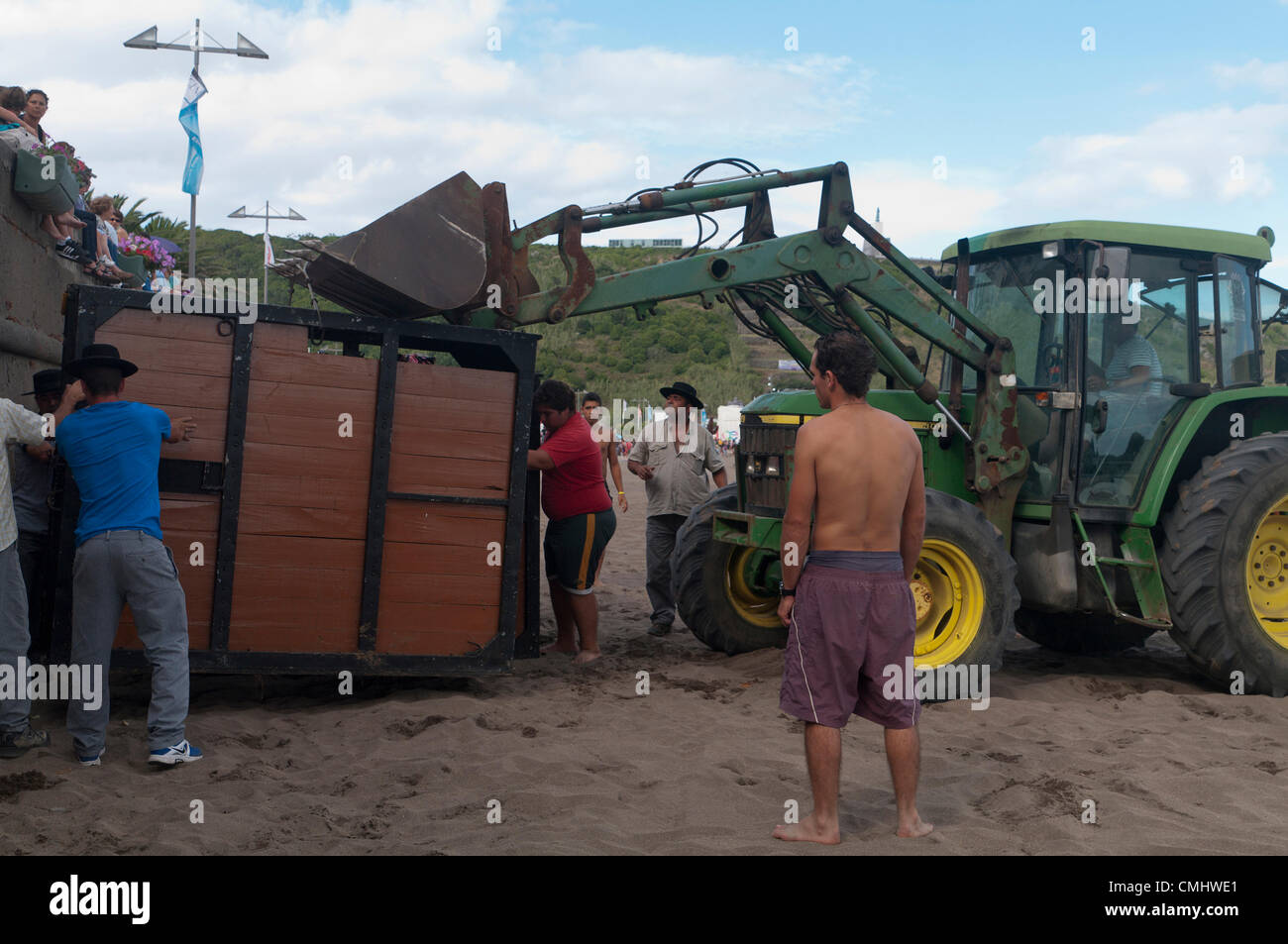 Preparativi per la corrida sulla spiaggia di sabbia di Praia da Vitória, isola di Terceira, Azzorre, Portogallo, con folle che si radunano per assistere all'evento. 11 agosto 2012. Corrida sulla spiaggia di sabbia della città di Praia da Vitória, Azzorre (il bestiame proveniva dagli allevatori Herdeiros de Ezequiel Rodrigues) i tori arrivano dai prati all'arena sulla spiaggia di sabbia per le più grandi feste dell'isola di Terceira Foto Stock