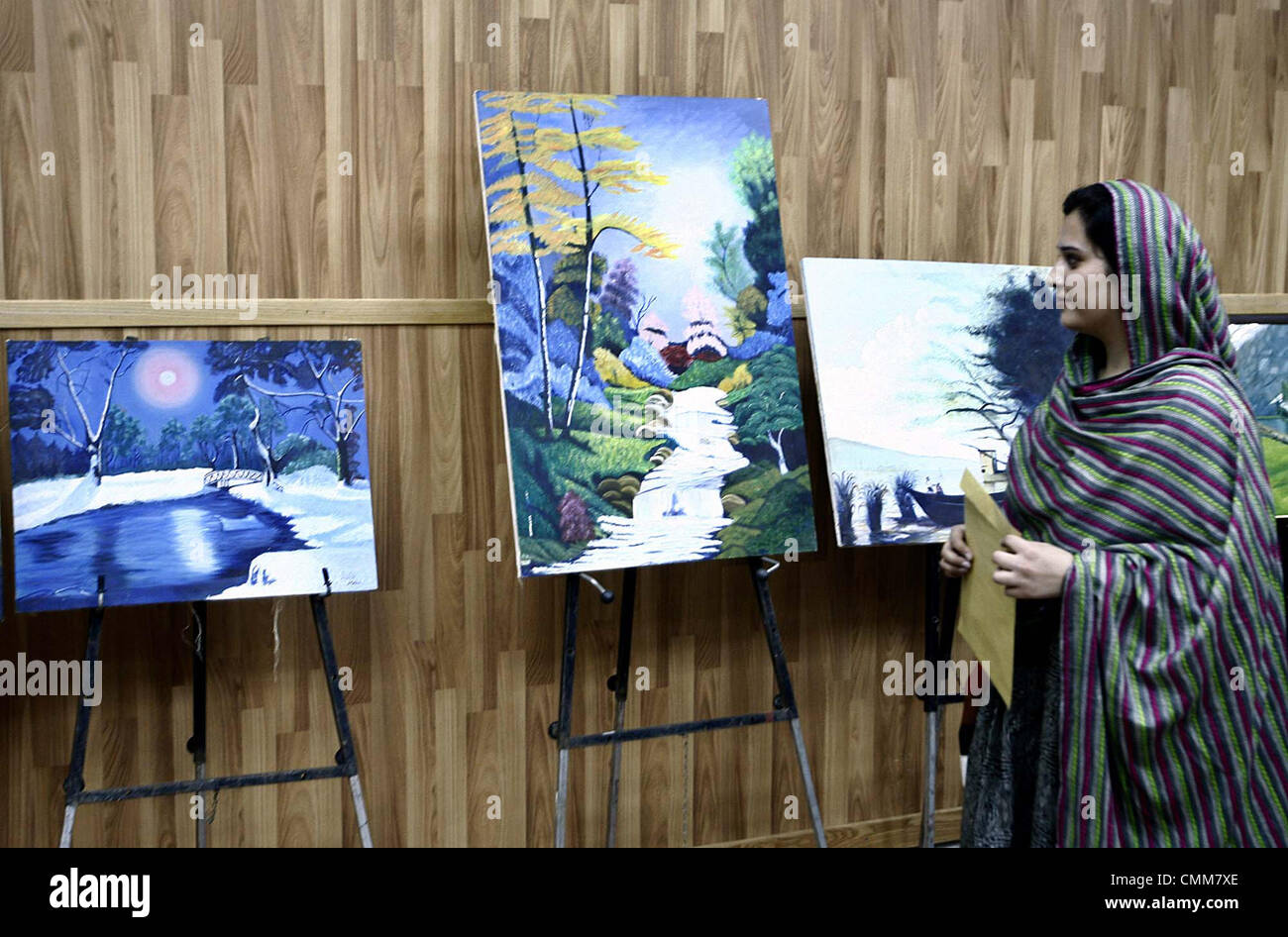 Visitatori tiene vivo interesse per la pittura visualizzati in corrispondenza di una galleria nel corso di una mostra disposto dell iraniana Centro Culturale a Peshawar Martedì, Novembre 05, 2013. Foto Stock