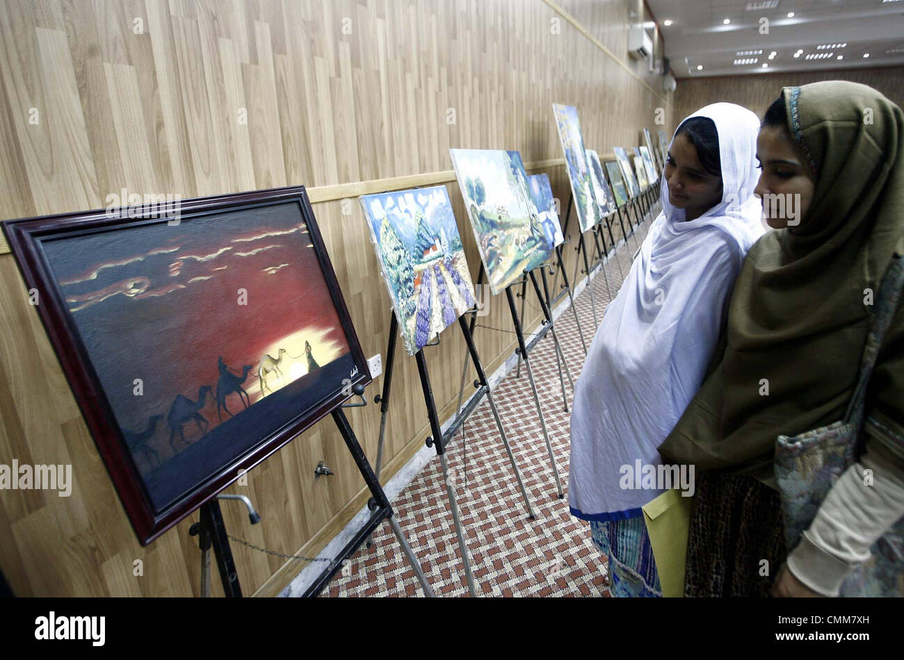 Visitatori tiene vivo interesse per la pittura visualizzati in corrispondenza di una galleria nel corso di una mostra disposto dell iraniana Centro Culturale a Peshawar Martedì, Novembre 05, 2013 Foto Stock