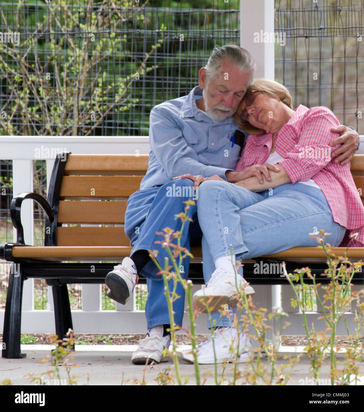 Bianco senior caucasico giovane uomo e donna che dorme su una panchina nel parco. Foto Stock