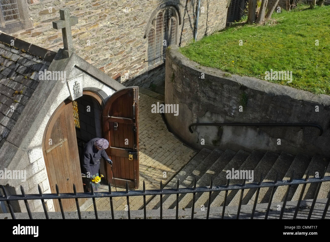 Una vecchia signora lasciando la chiesa di domenica mattina Foto Stock