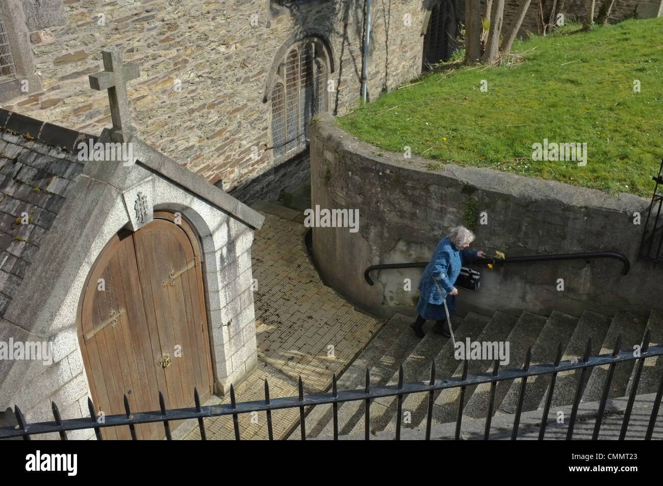 Una vecchia signora lasciando la chiesa di domenica mattina Foto Stock
