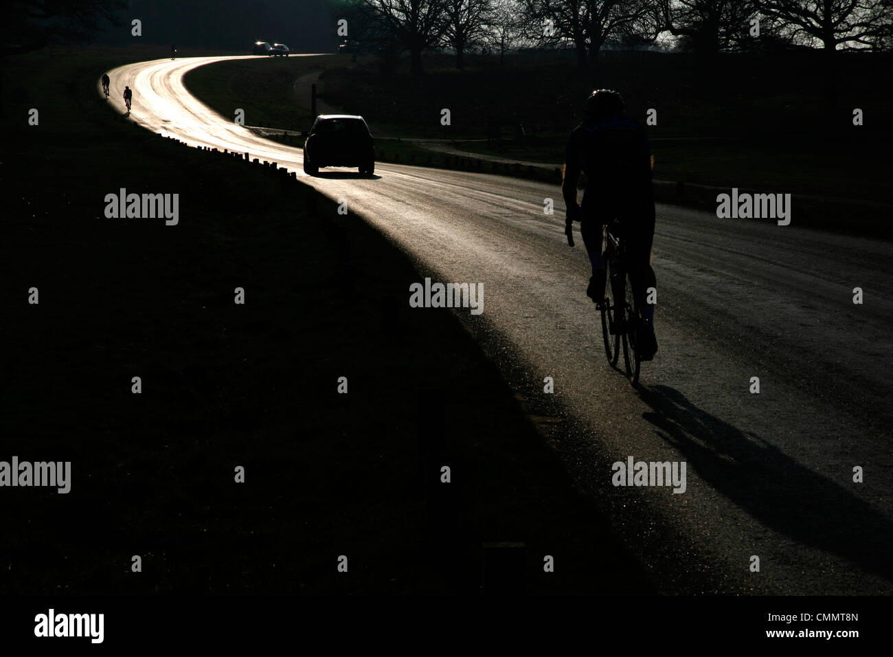 I ciclisti e le automobili viaggiano attraverso il parco di Richmond a segatori Hill, Richmond, London, Regno Unito Foto Stock