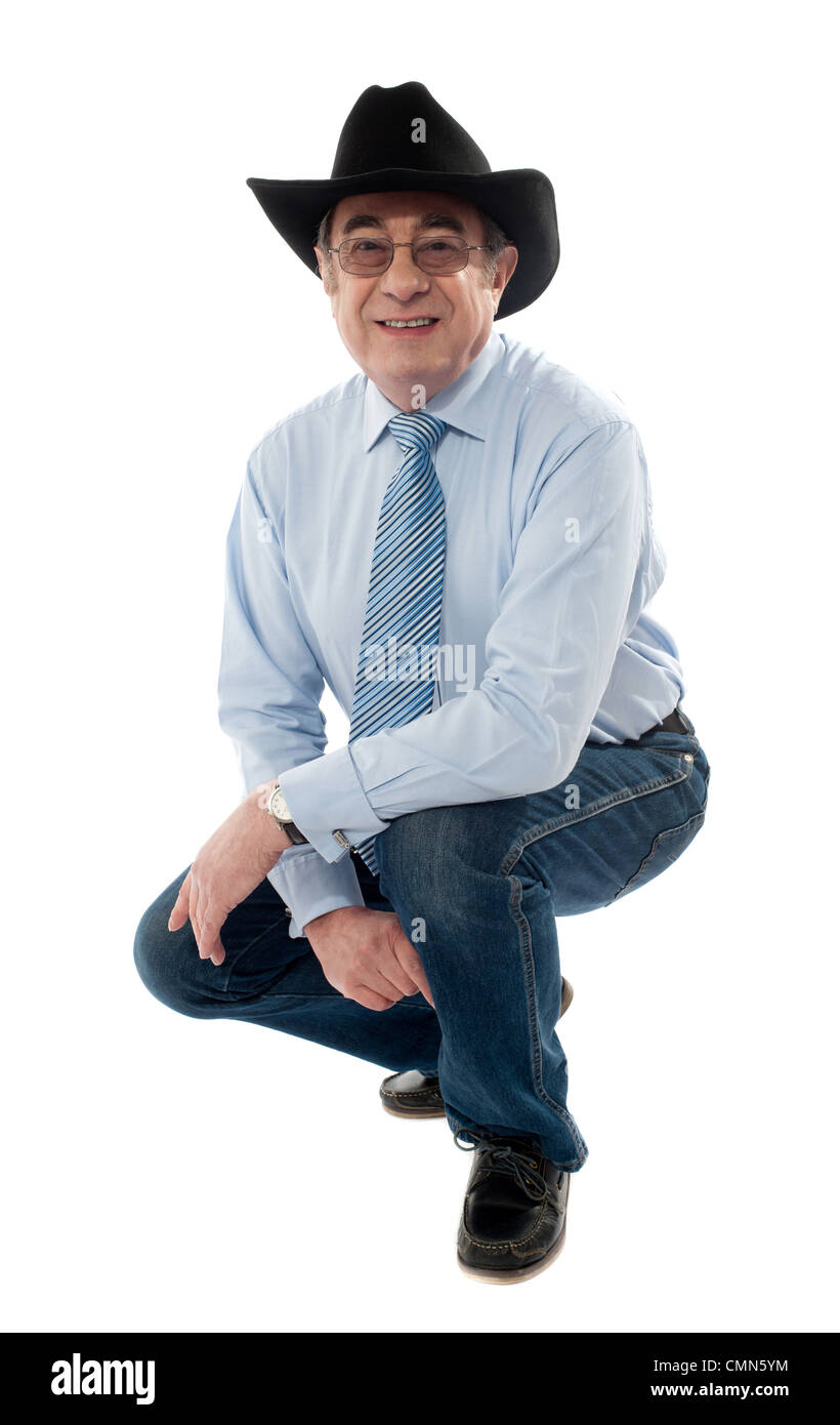Immagine di un cowboy senior in posa semi seduto isolato su bianco Foto Stock