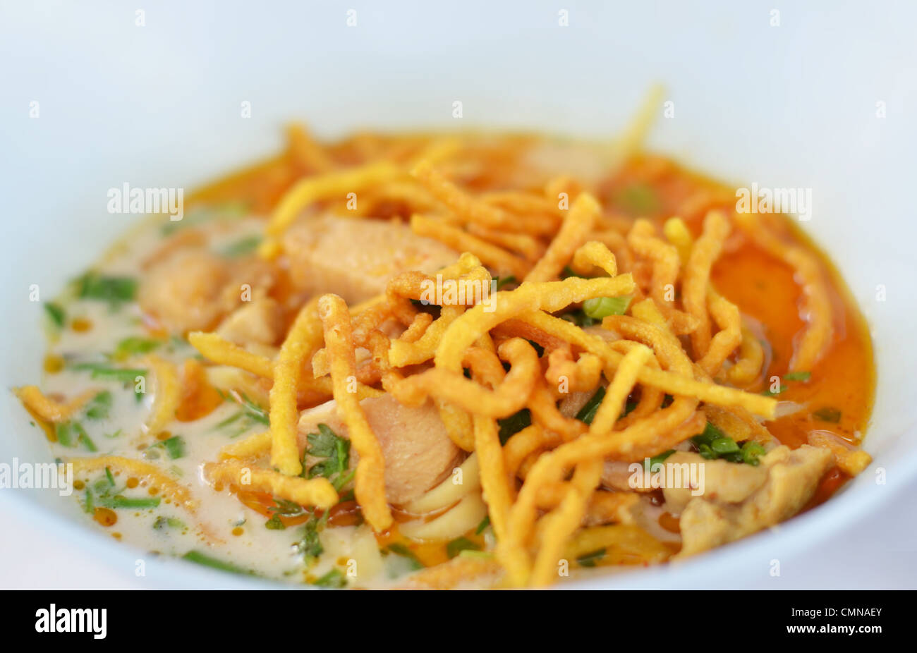 Un piatto di pasta in un giallo curry con pollo. Khao Soy una famosa cucina della Tailandia del Nord. Foto Stock