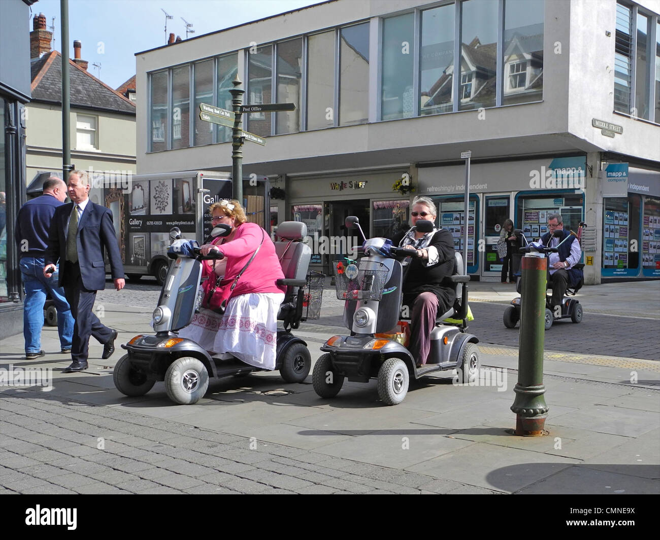 Persone con mobilità scooter in un centro commerciale, centro città. Questa immagine è EDITORIALE SOLTANTO E NON DEVE ESSERE UTILIZZATO IN QUALSIASI MODO che denigrano gli utenti di scooter questo è in West Street, Horsham, West Sussex. Foto Stock