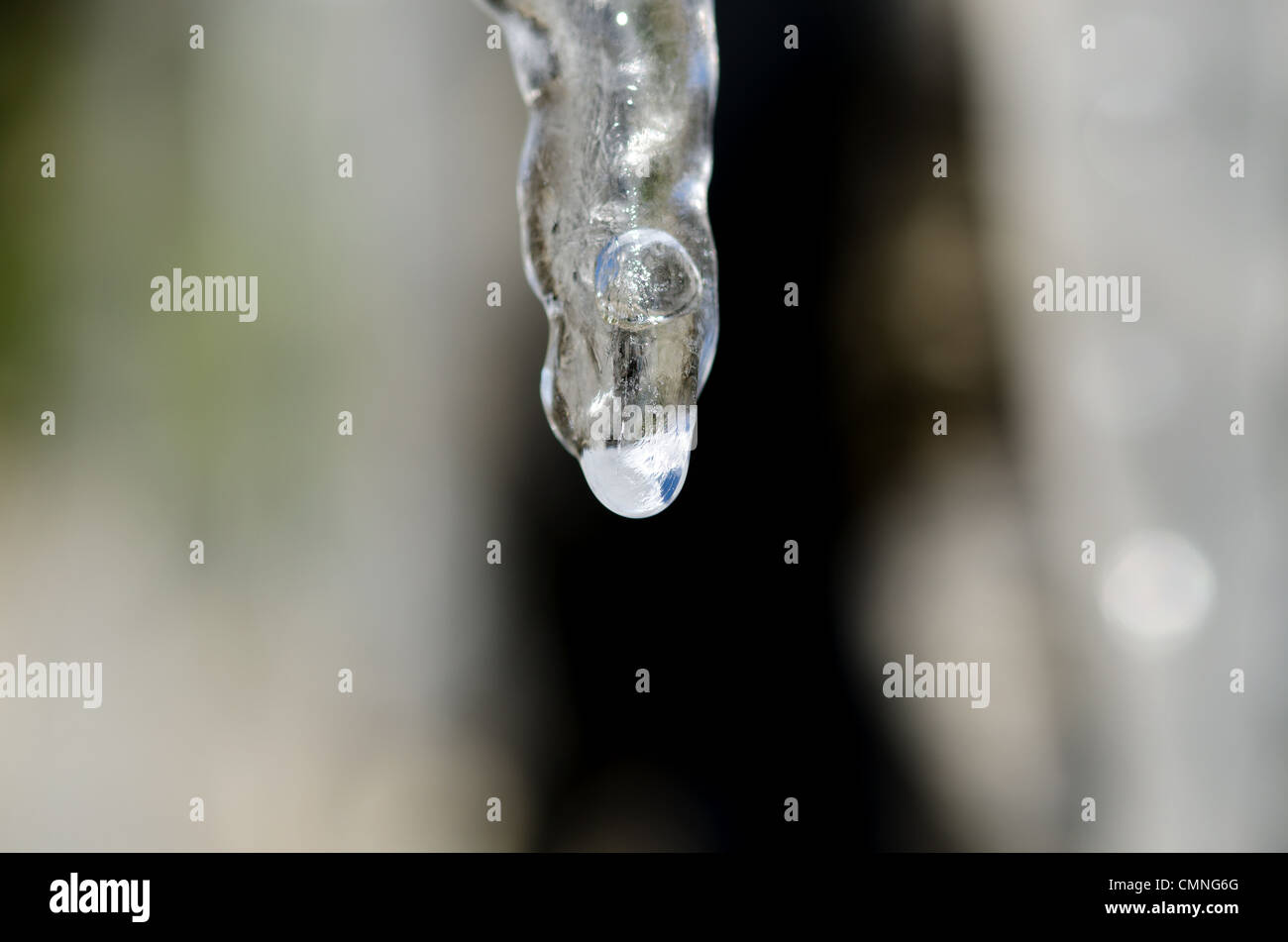 Stalattiti di ghiaccio con acqua scende al di sotto di un tetto Foto Stock