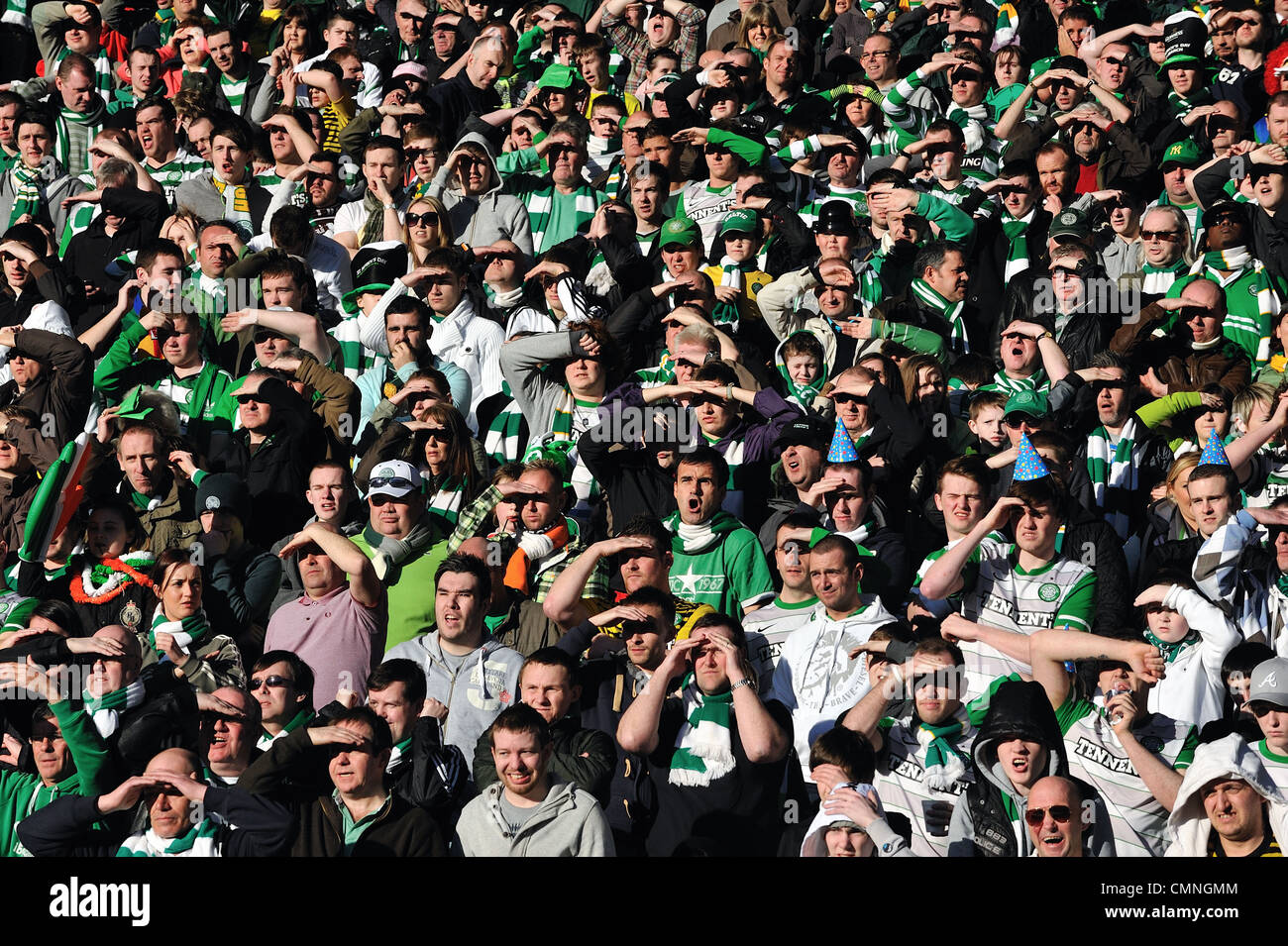 I sostenitori del Celtic scudo ai loro occhi dal sole a guardare la loro squadra in finale di League Cup a Hampden Stadium. Foto Stock