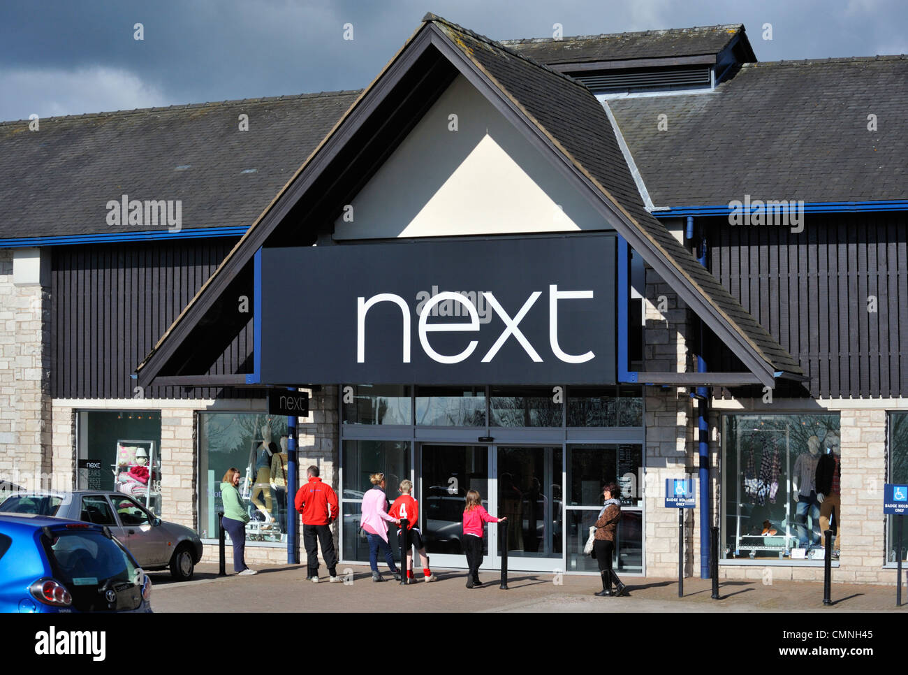 I clienti in attesa per 'avanti' store per aprire. Il vecchio Show Terra, Kendal Cumbria, England, Regno Unito, Europa. Foto Stock