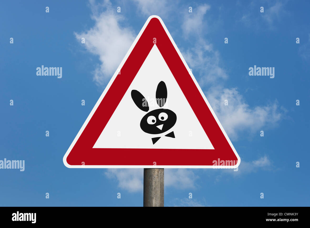 Dettaglio foto di una segnaletica di pericolo con un coniglietto di Pasqua nel mezzo, lo sfondo del cielo. Foto Stock