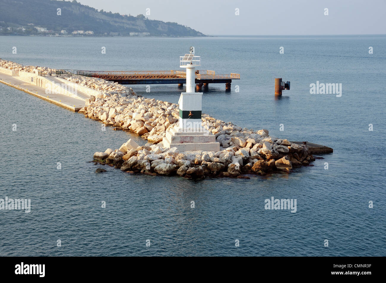 Faro Αutomated dal mare e roccia molo frangiflutti ad entrare in porto. Foto Stock
