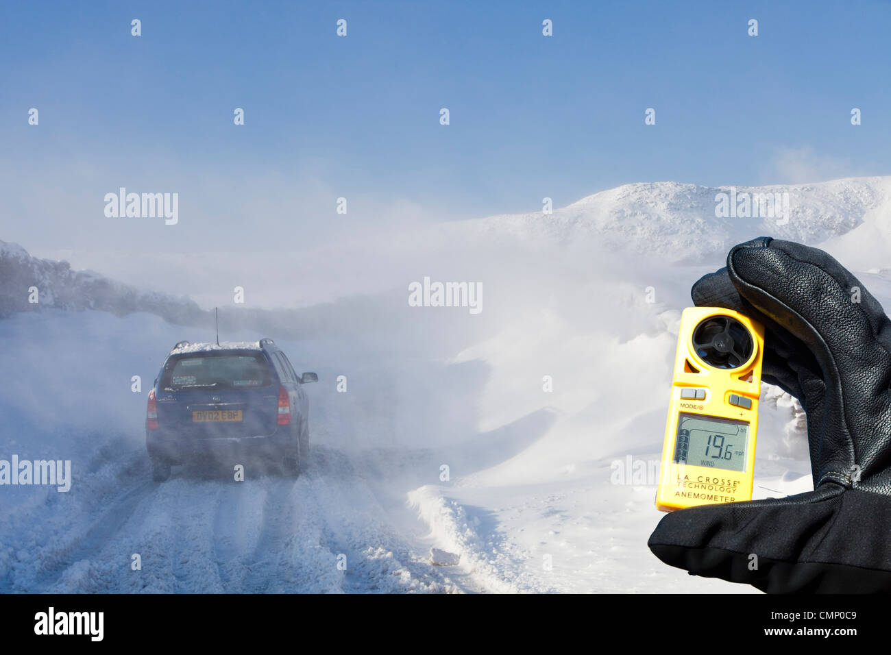 Un auto è abbandonato sul Kirkstone pass road sopra Windermere dopo che è stato bloccato dalla spindrift e soffiata dal vento, neve Foto Stock