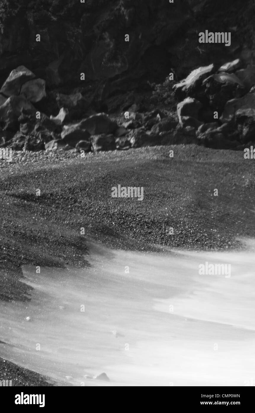 Pietre e navigare in bianco e nero. Una lunga esposizione shot prese a Big Island, Hawaii, Stati Uniti d'America su di una spiaggia di ciottoli di mattina. Foto Stock