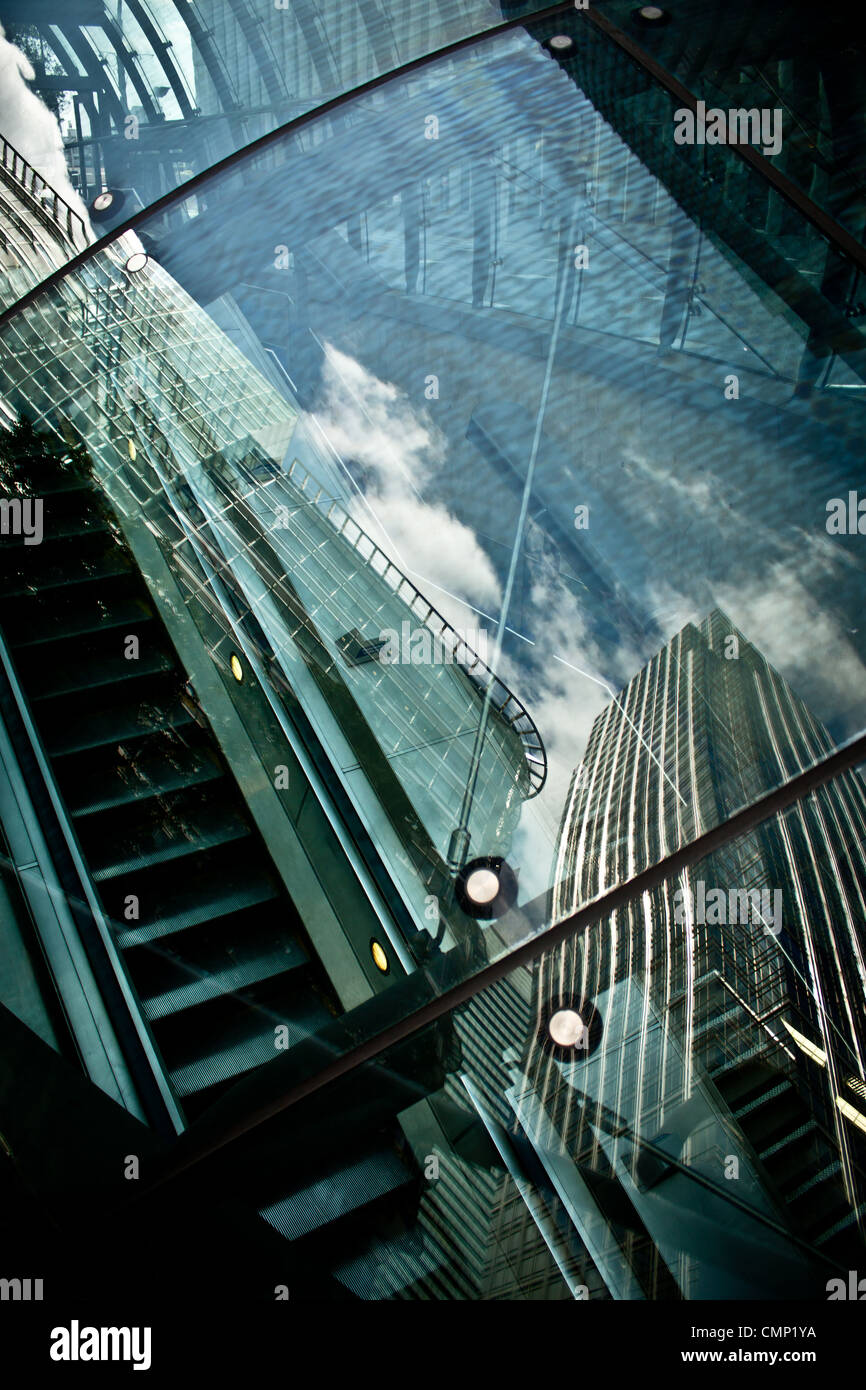 Business riflettente cityscape guardando verso il basso attraverso il vetro presso la stazione della metropolitana di Escalator. Foto Stock