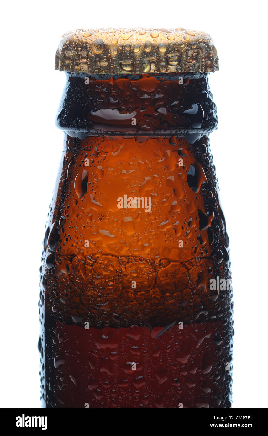 Primo piano di una birra bruna collo di bottiglia e tappo coperto con condensazione. Formato verticale su uno sfondo bianco. Foto Stock