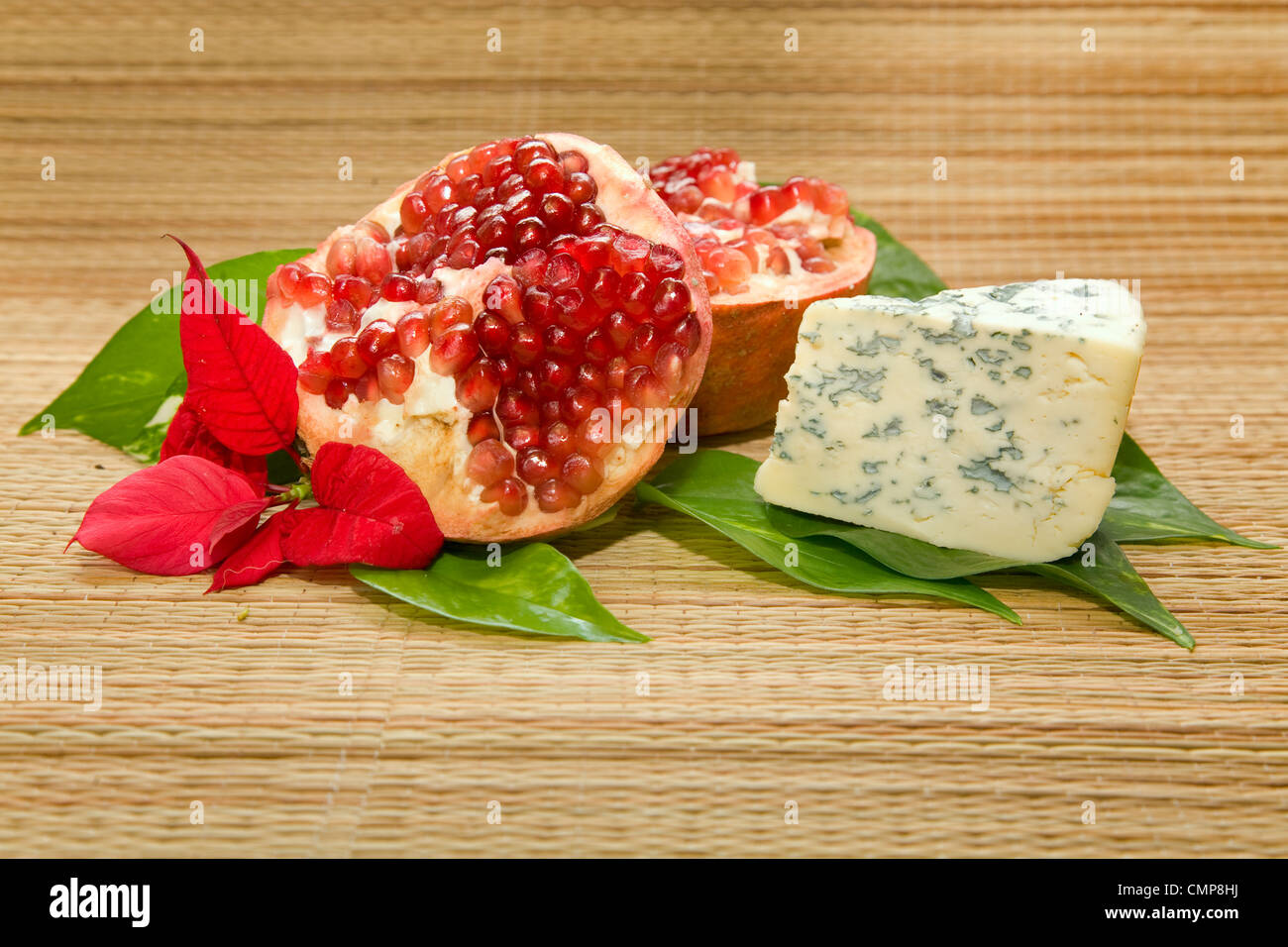 Formaggio con stampo, melograno e foglia sul materassino Foto Stock