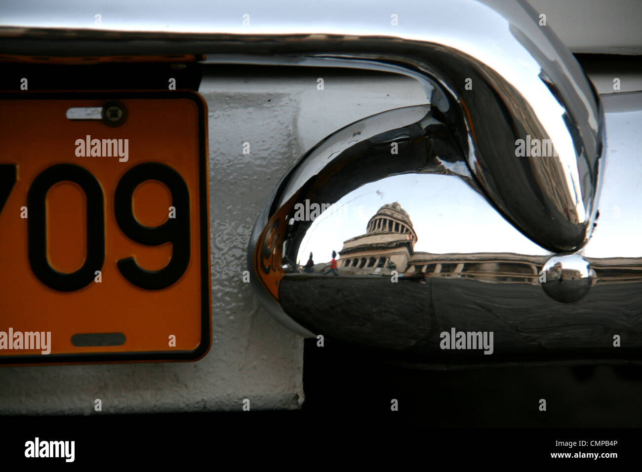 Una chiusura di un'auto d'epoca numero/targa in Havana, Cuba con il Capitol Building riflessa nel paraurti cromato. Foto Stock