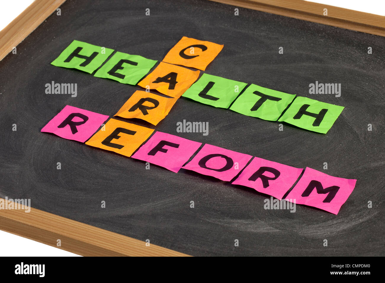 Della riforma sanitaria crossword - colorata sticky notes su una scuola lavagna con gesso bianco texture Foto Stock