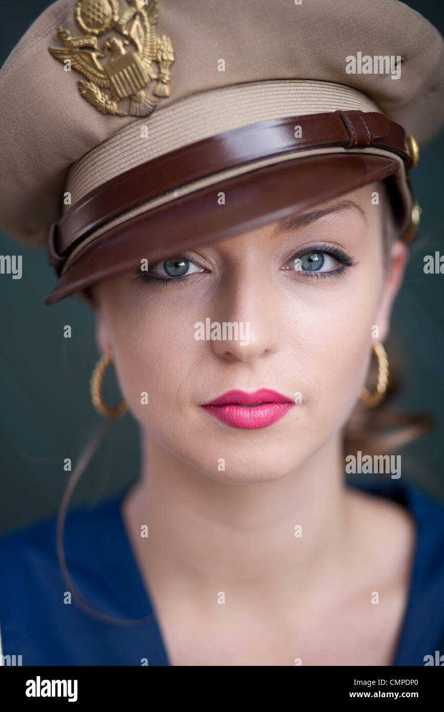 Fotografia di una bella donna bionda con un vintage o aspetto retrò indossando un cappello da forze armate. Foto Stock