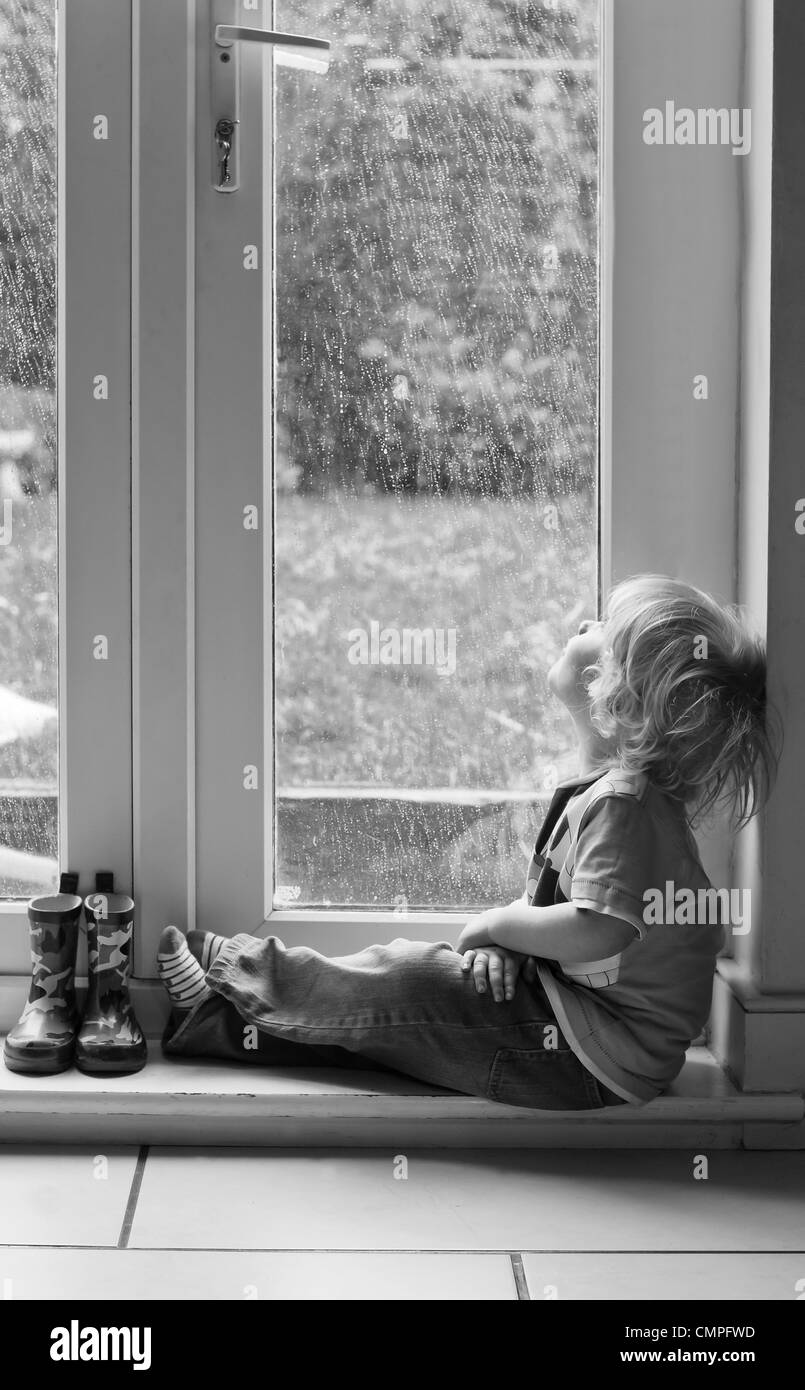 Il Toddler guardando la pioggia Foto Stock