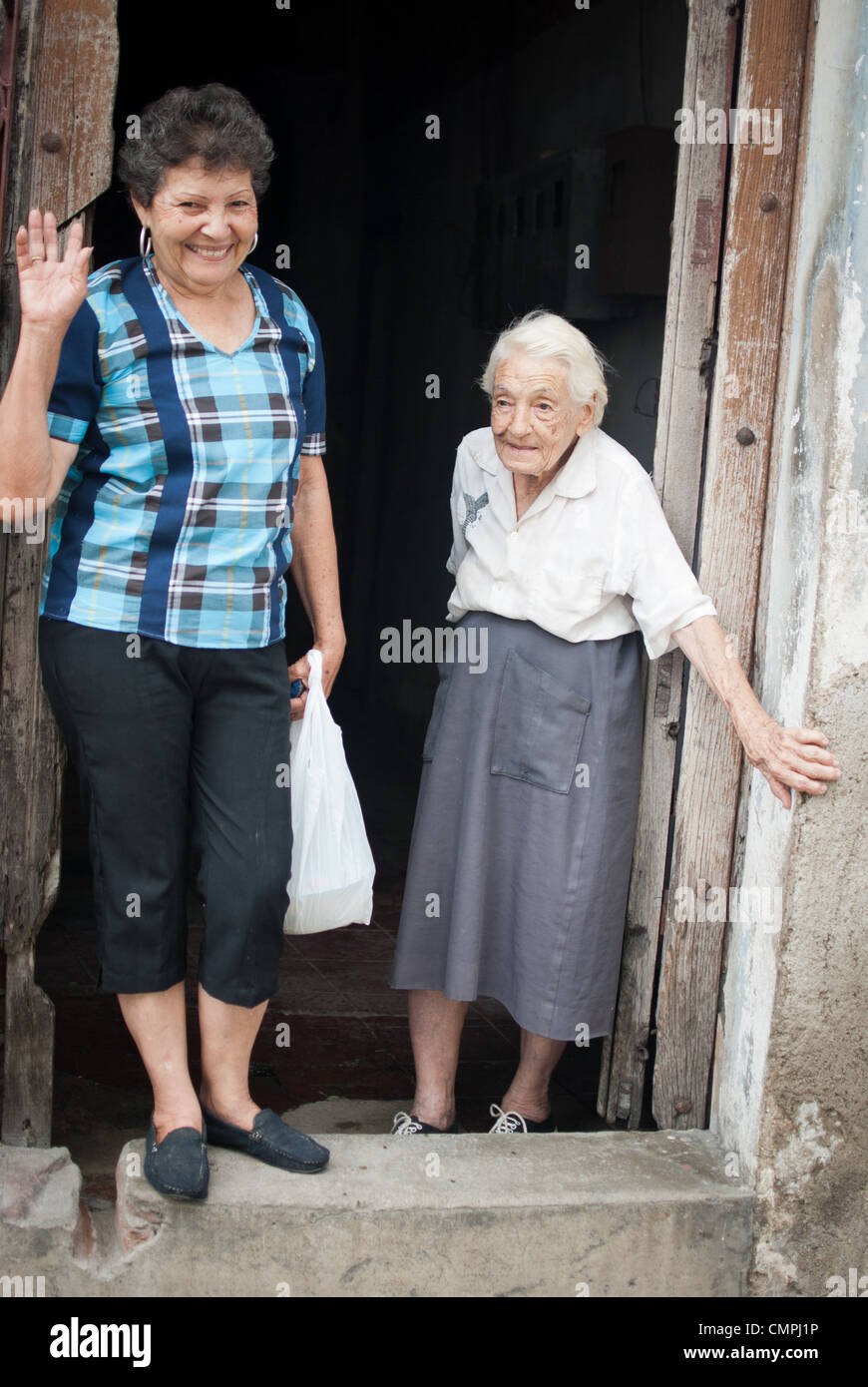 Due donne cubane appeso al di fuori della casa, Camaguey, Cuba Foto Stock