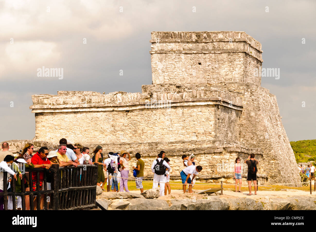 I turisti presso le rovine della civiltà Maya città a Tulum si affacciano sul Mar dei Caraibi con El Castillo in background. Foto Stock
