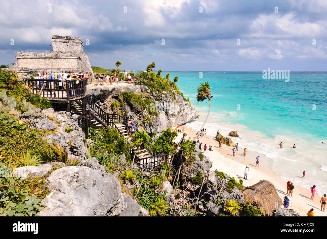 Le rovine della civiltà Maya città a Tulum, sulla costa della penisola dello Yucatan del Messico. In alto a sinistra è la struttura in pietra conosciuta come El Castillo. Nel centro è un passaggio dalle rovine giù per la spiaggia di sabbia bianca di seguito. Foto Stock