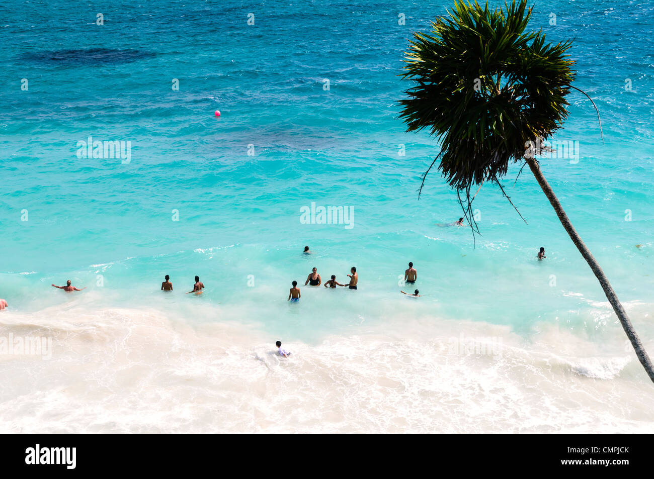 TULUM, Messico - Persone nuotare nel mare dei Caraibi da una delle splendide spiagge accanto alla civiltà Maya rovine di Tulum sulla costa orientale della penisola dello Yucatan del Messico. Foto Stock