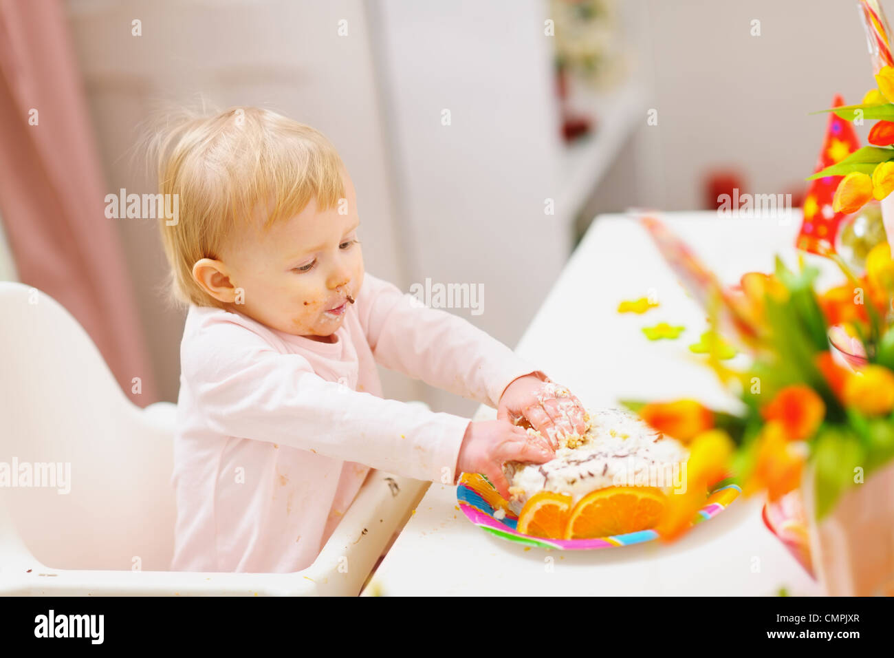 Mangiare cosparso il bambino toccato torta di compleanno da mani Foto Stock