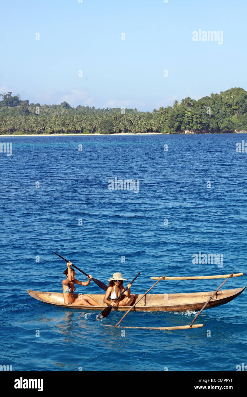 Giovani donne canoa outrigger piroga. Simakakang, isole mentawai, a ovest di Sumatra, Sumatra, Indonesia, sud-est asiatico Foto Stock